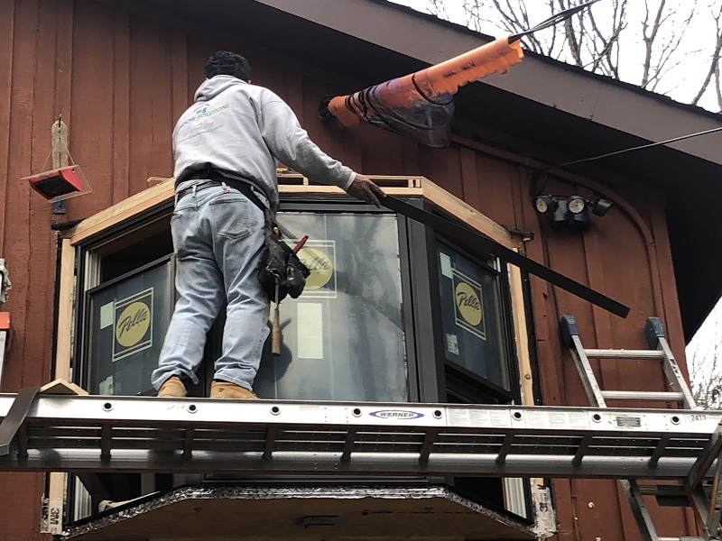 Window Solutions Plus master installer building a custom roof over this bay window